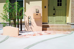 優しい色で統一された門まわりにフィットするガラス表札G-05